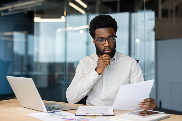istock Focused professional reviewing documents in a modern office workspace 2235987476