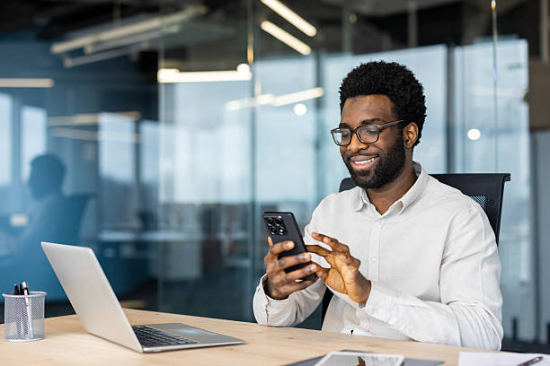 istock Smiling businessman using smartphone in modern office 2235987527