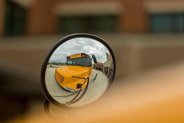 A yellow school bus viewed through a convex mirror. Back to school.