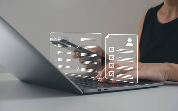 istock Businesswoman using laptop and smartphone with digital checklist and task management interface. Concept of productivity, digital workflow and online project planning tools. Human resource management. 2235995378