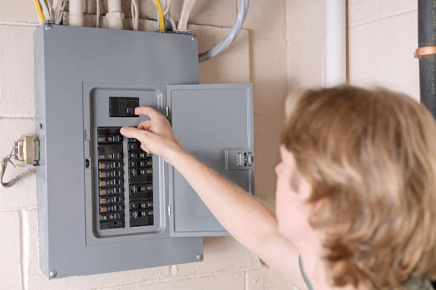 A man is shutting off the main circuit breaker