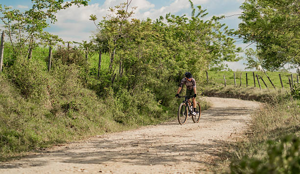 istock Cyclist on a dirt road surrounded by green nature 2235999496