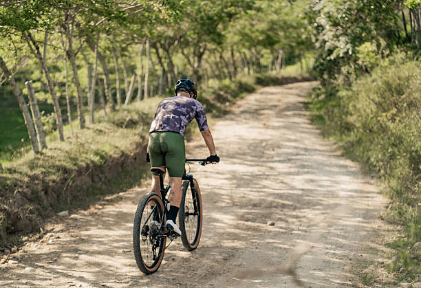 istock Cyclist climbing a rural road surrounded by nature 2235999498