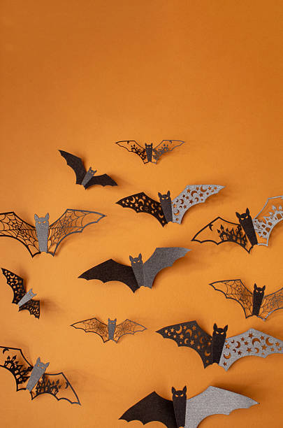 istock Halloween bats fly on orange background. Copy space invitation card 2236002765