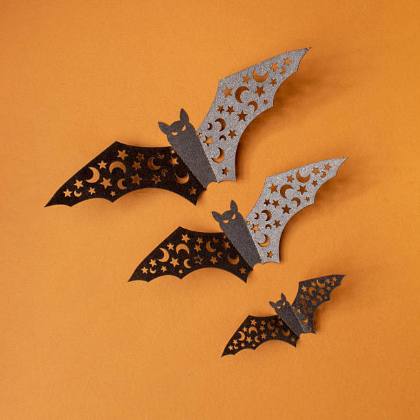istock Halloween bats fly on orange background. Copy space invitation card 2236002774