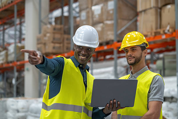 istock Men in safety gear discuss plans pointing in warehouse area 2236005335