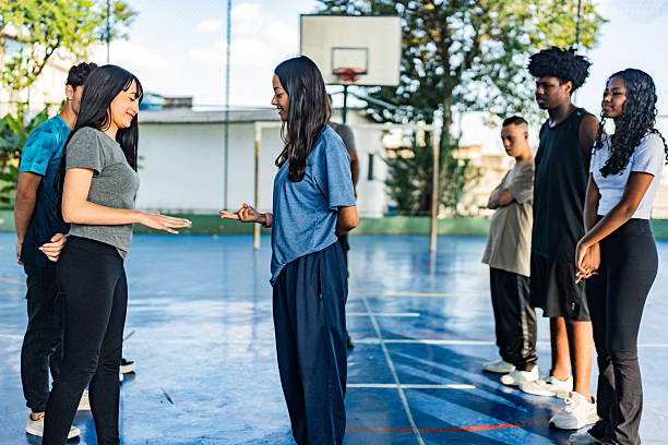 istock Students doing rock paper scissors on a school sport court 2236008137