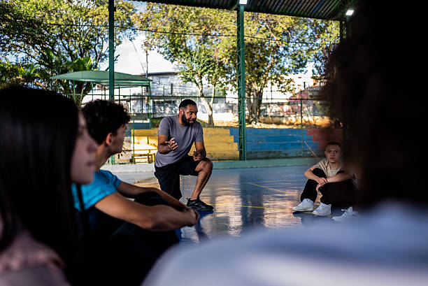 istock Physical education teacher instructing students during class on a school sports court 2236009541