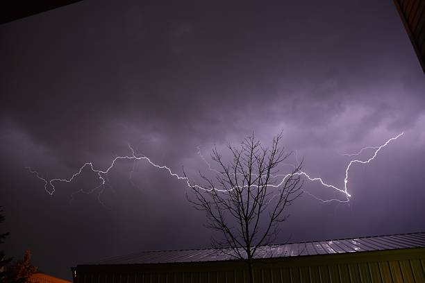istock lightning streaks from a tree in the sky above a building 2236009596
