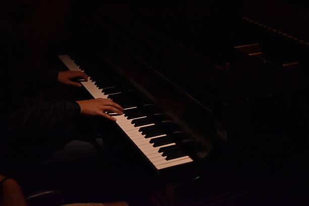 istock someone is playing a piano in the dark with their hands 2236009660