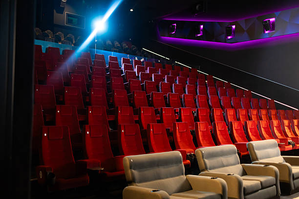 istock Empty cinema auditorium with comfortable red seats and a light beam 2236009753