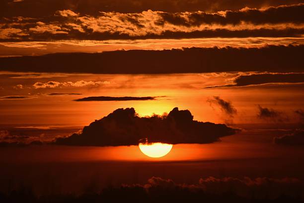 araffe sunset with a cloud and a sun setting in the sky