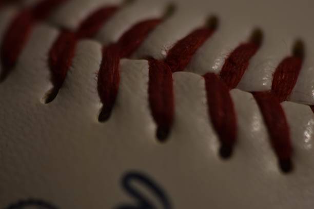 a close up of a baseball with a red stitching on it