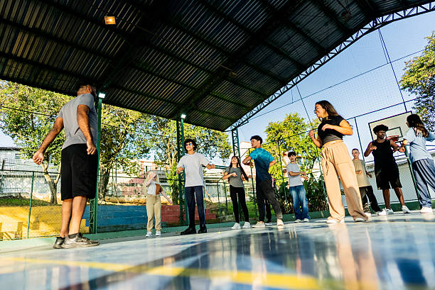 istock Group of students doing stretching exercises during physical education class on the school's sports court 2236009818