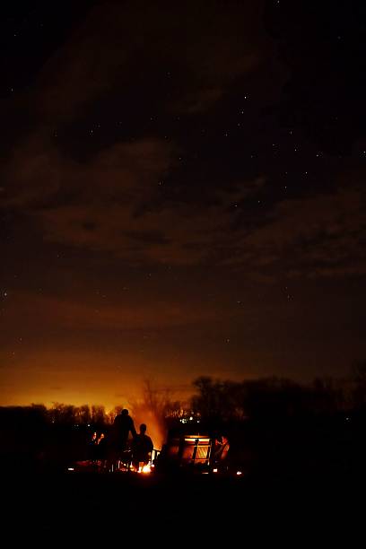 istock nighttime sky with a couple of people sitting around a campfire 2236010201