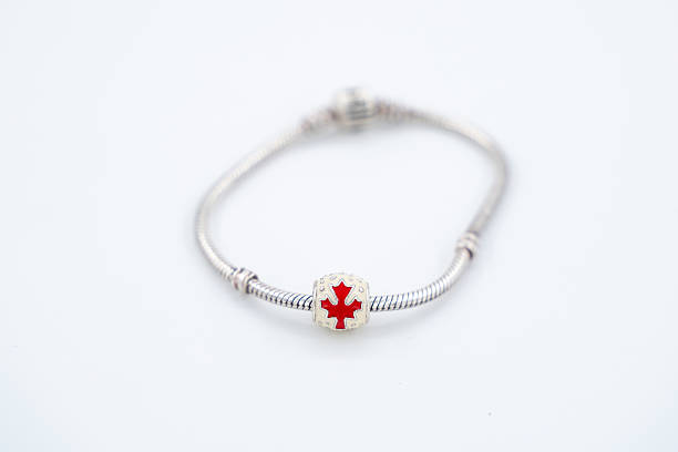 Close up of silver bracelet with Canada red maple leaf charm.