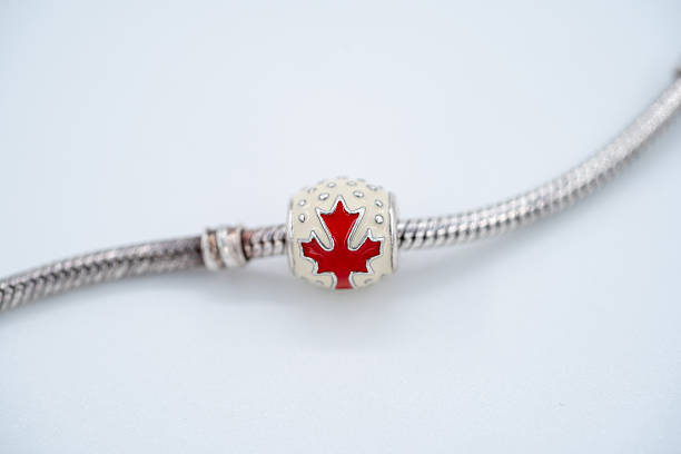 istock Close up of silver bracelet with Canada red maple leaf charm. 2236017263