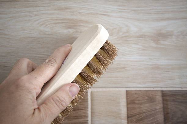 A person holding a cleaning brush in hand. Close-up concept of household chores and cleaning.