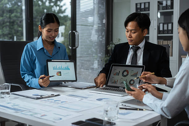 Entrepreneurs, marketers, managers, and financial analysts gather around the table to analyze data, present results, plan strategies, discuss efficiencies,grow their businesses through collaboration