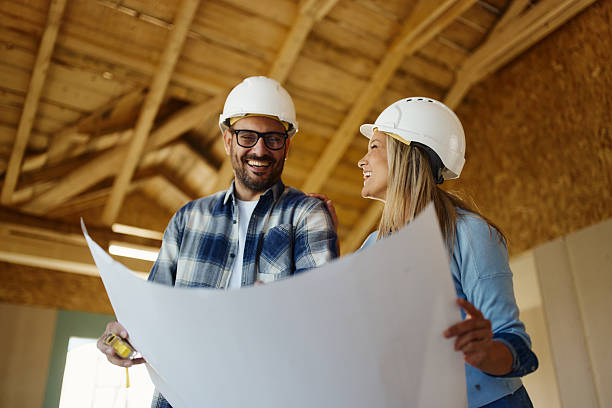 istock Happy couple reading housing plans at construction site. 2236029116