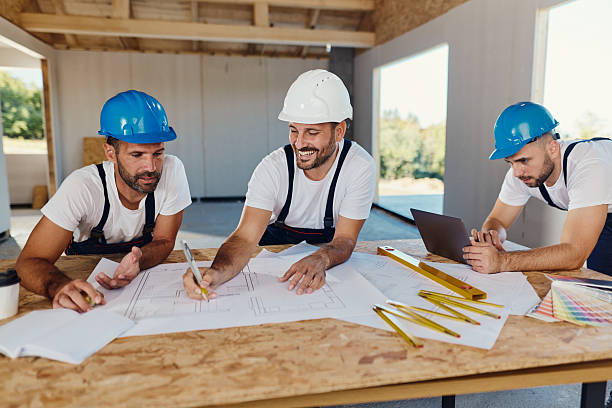 istock Team of workers working on plans and laptop at construction site. 2236029167
