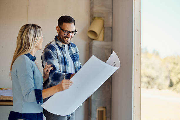 istock Happy couple reading blueprints of their developing house. 2236029192