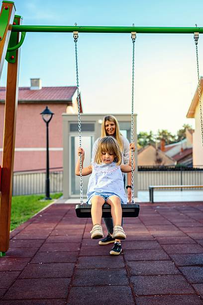 istock Cute Little girl using a swing on a daycare playground 2236030613