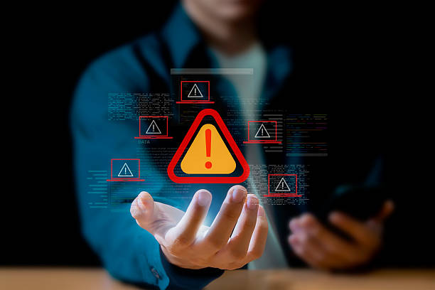 istock Programmer uses laptop with warning triangle sign to alert for errors and maintenance concepts. 2236032682