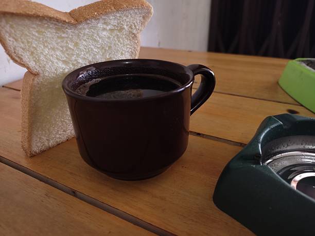 Black Coffee and White Bread on Wooden Table