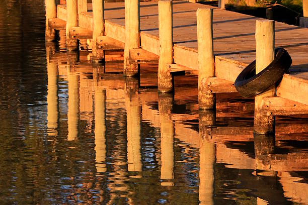 The early morning light strikes the timber structure of the boat mooring jetty