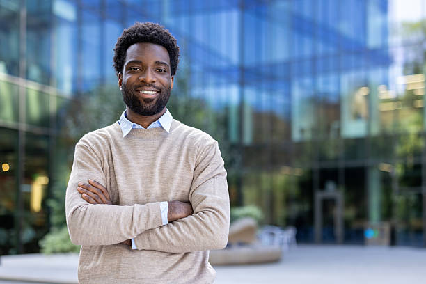 istock Happy businessman standing outside an office building, smiling confidently. 2236036103