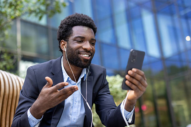 istock A businessman is smiling while having a video call on his smartphone outside. 2236036200