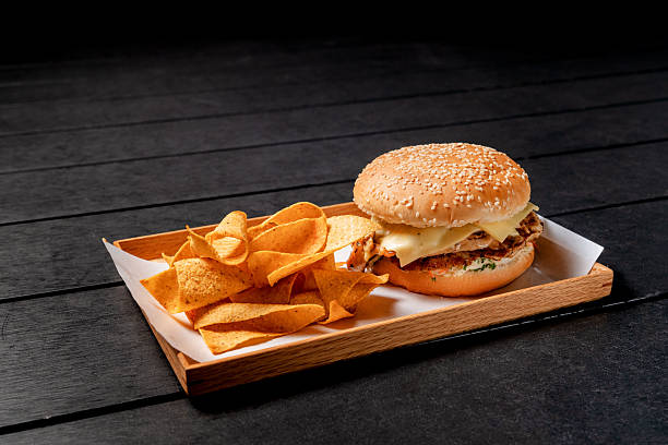 Cheese Chicken Burger with Corn Chips on a Wooden Serving Tray