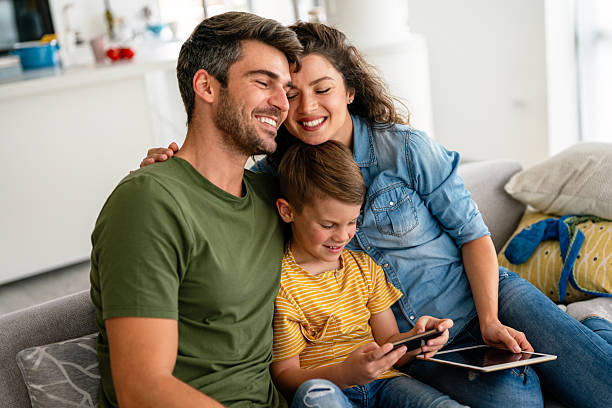 istock Parents and child relaxing at home with computer watching funny internet video, making online call 2236042124
