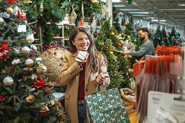 istock Smiling young woman using smartphone during holiday shopping 2236043143