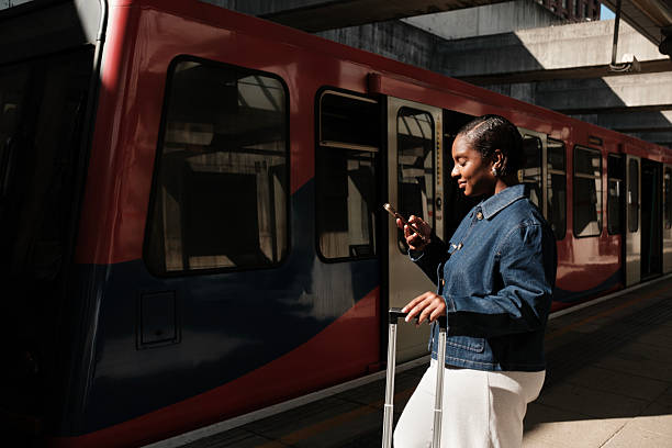 istock Young black woman waiting for train and using smartphone 2236043374
