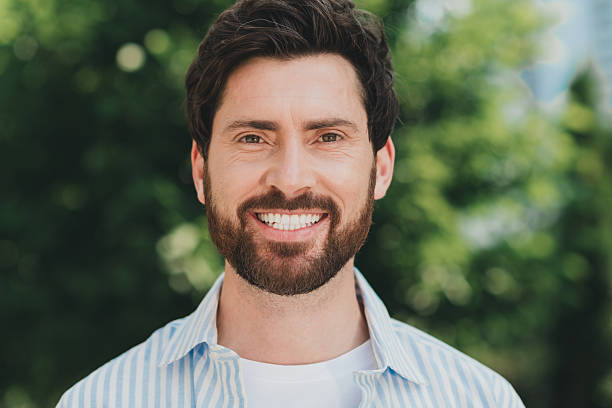 istock Smiling young man enjoying a sunny day outdoors in an urban environment with greenery during a leisurely walk 2236043953