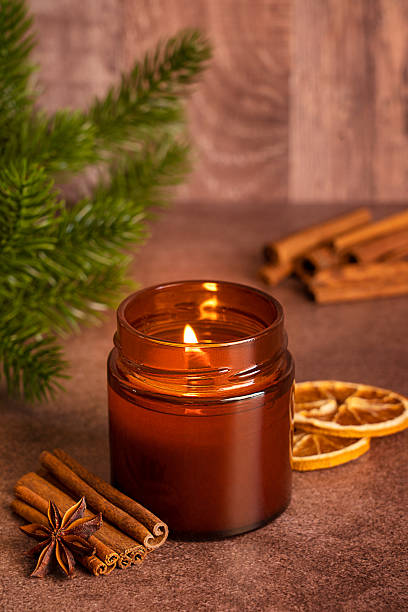 istock Cozy candlelight scene with cinnamon, anise and pine tree branch on brown table 2236044107