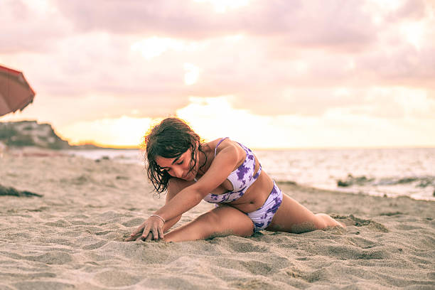 istock A woman is doing a yoga pose on the beach 2236044550