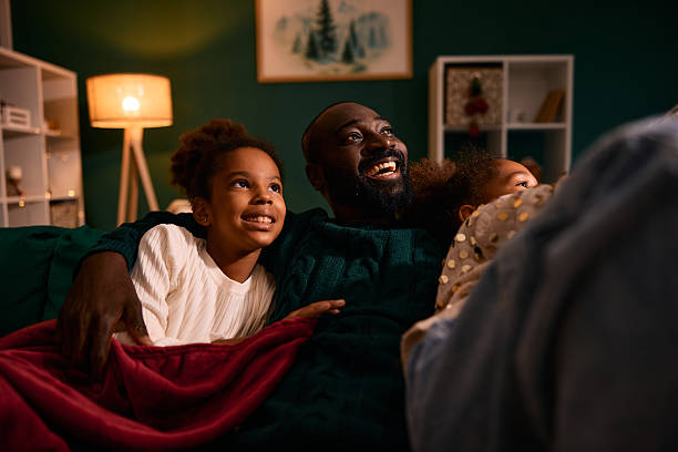 istock Father and daughters watching movie together feeling happy 2236045022
