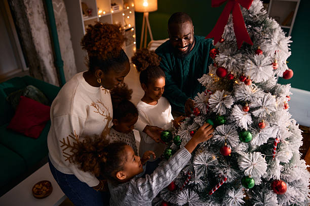 istock Black family decorating Christmas tree together for holidays 2236045036