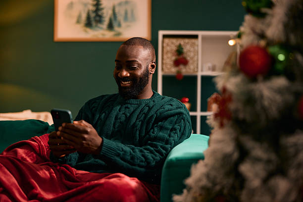istock Man smiling using phone relaxing during Christmas holiday 2236045259
