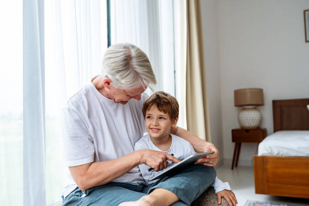 istock Grandfather Bonding with Grandson While Using a Tablet at Home 2236045628