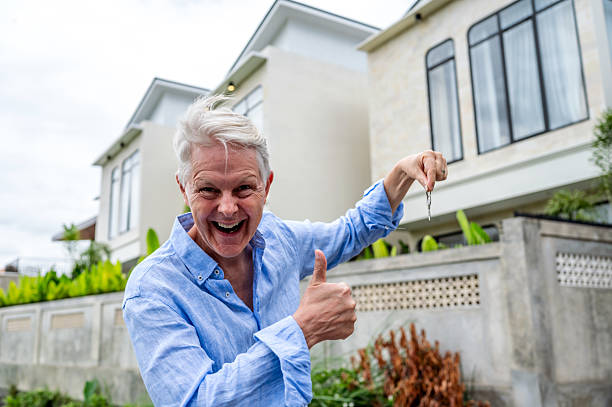 istock Happy Elderly Man Holding Keys Outside a Modern House 2236046532