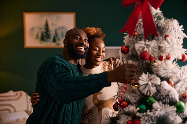 istock Happy couple decorating Christmas tree for holiday celebration 2236046769