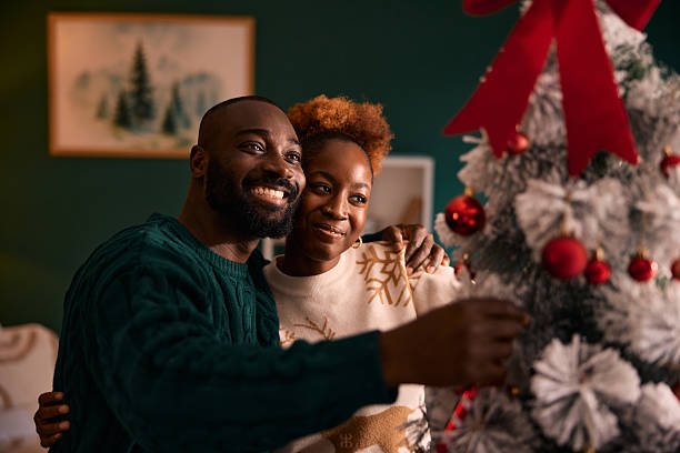 istock Black couple decorating Christmas tree together during holidays 2236046785