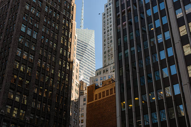 Central district of New York City with tall buildings and traffic jam on the streets under clear sky