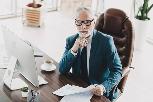 istock Professional mature businessman at office desk working on documents in a modern corporate workspace setting 2236048719