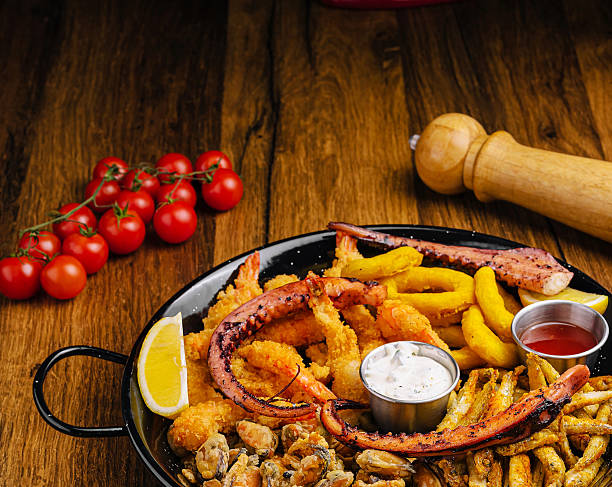 Seafood platter featuring shrimp, octopus, and fried vegetables on wooden table