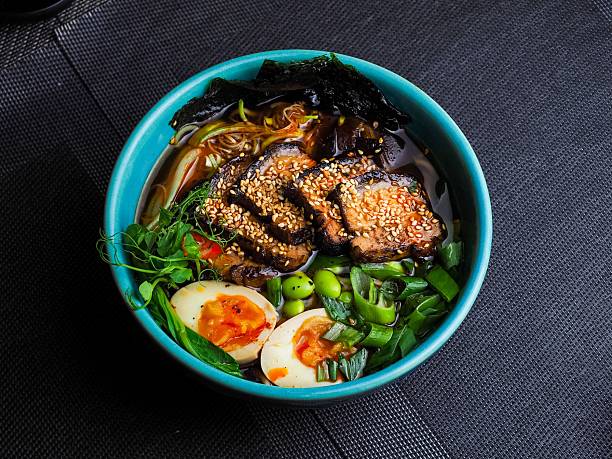 Colorful ramen bowl with eggs and greens.
